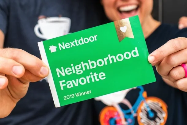 happy hands holding a green Nextdoor Neighborhood Favorite card