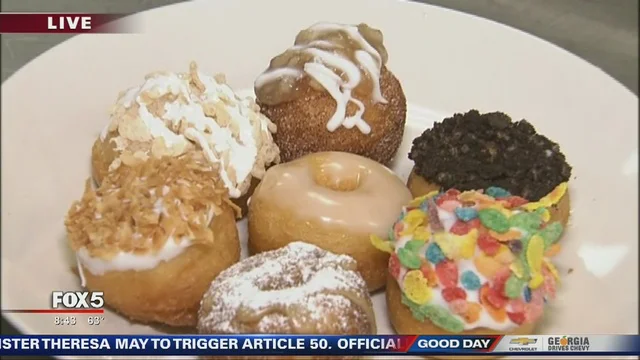 Seven donuts on a plate with assorted toppings
